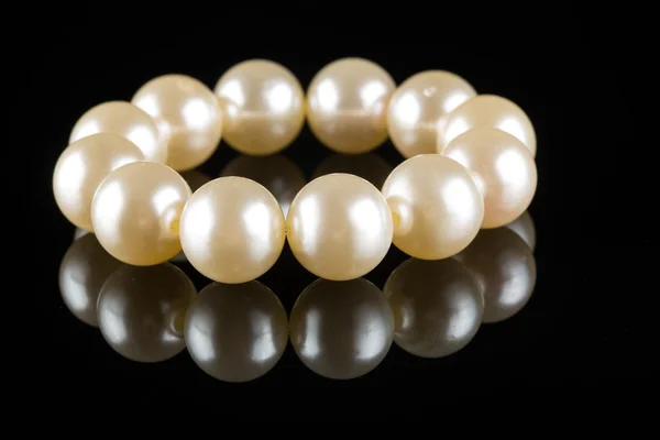 Bílé perly na černém pozadí. Luxusní náramek. — Stock fotografie