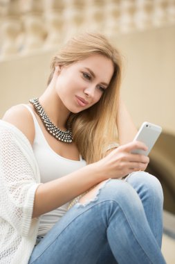 genç kadın bir kısa mesaj okuma. sokakta