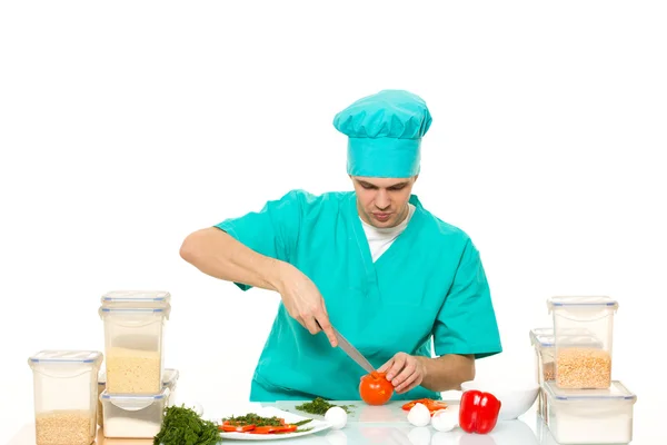 Vriendelijke chef-kok voorbereiding van groenten in zijn keuken. peper houdt — Stockfoto