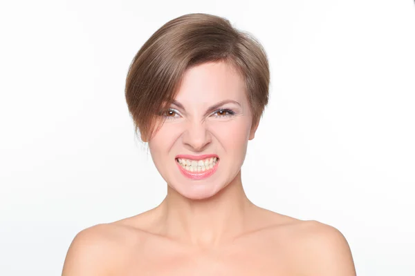 Portrait of a beautiful woman with bare shoulders and short hair.  growls irritably. It expresses aggression, showing teeth. — Stock Photo, Image