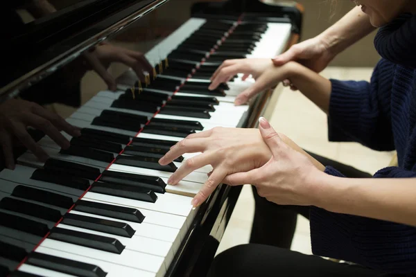 女子双手放在钢琴的键盘上。女孩玩。音乐老师 — 图库照片