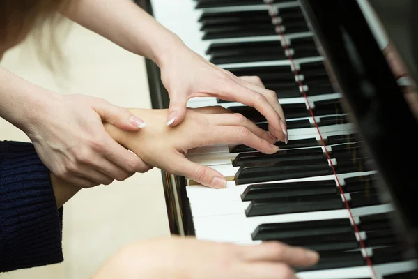 女子双手放在钢琴的键盘上。女孩玩。音乐老师 — 图库照片