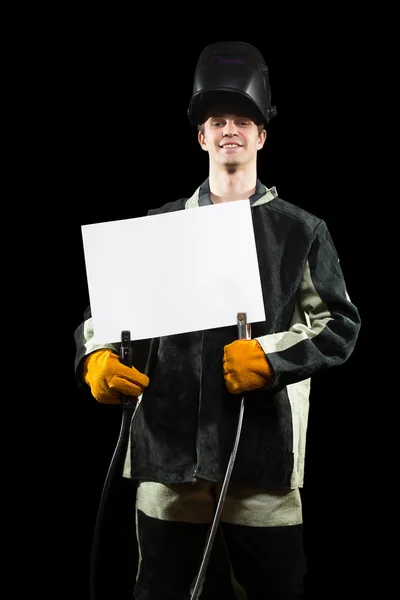 Handsome welder holding a blank form. isolated on black background — Stock Photo, Image