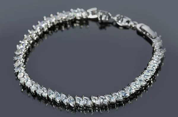 Pulsera de plata con diamantes sobre fondo gris . — Foto de Stock