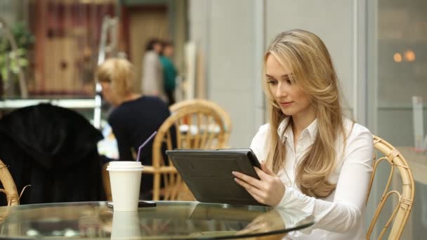 Женщина с планшетного компьютера сенсорный экран в кафе пить кофе — стоковое видео