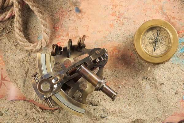 Conjunto de instrumentos náuticos, acostado en la arena y el mapa viejo. concepto aventura — Foto de Stock