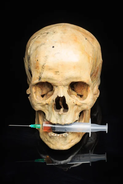 Cráneo y jeringa de líquido amarillento. drogas conceptuales —  Fotos de Stock