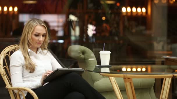 Femeie care utilizează ecranul tactil al computerului tabletă în cafenea care bea cafea — Videoclip de stoc