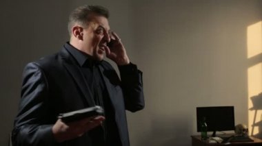kızgın işadamı telefonla söyledi silahını sallayarak. muhatap tehdit