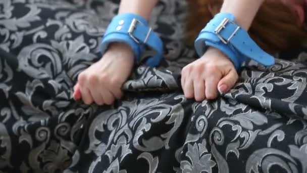 Vrouwelijke handen in leder handboeien. seksspeeltjes. — Stockvideo