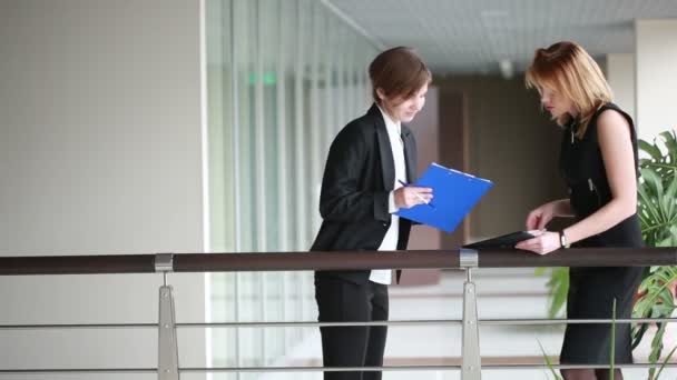 Duas mulheres de negócios a discutir um contrato. ir ao redor do escritório — Vídeo de Stock