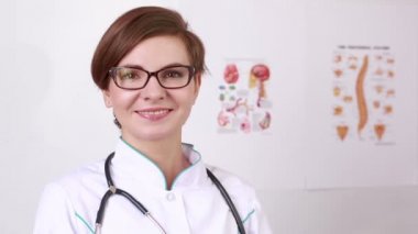 woman doctor with a stethoscope takes off his glasses. smiling at the camera
