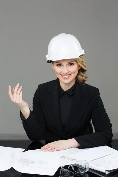 Woman architect with drawings. Beautiful girl in a building helmet — Stok fotoğraf