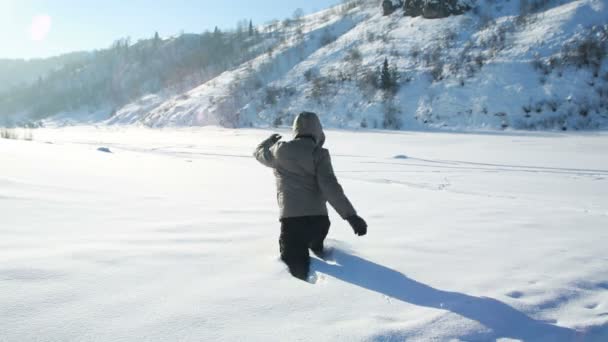 Молодой человек на свежем воздухе играет со снегом — стоковое видео