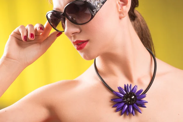 Stile di vita ritratto di moda di elegante giovane donna in occhiali da sole alla moda, collana luminosa. Estate colori brillanti . — Foto Stock