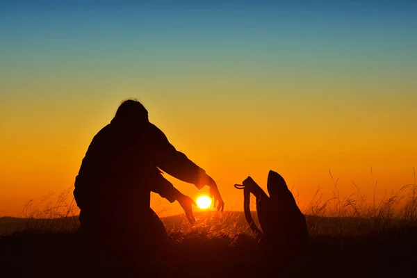 夕暮れ時に太陽をキャッチしようとしている女性のシルエット — ストック写真