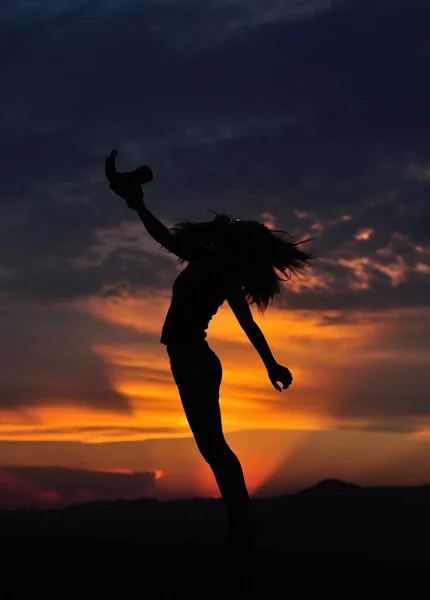 女の子のシルエットの写真カメラを手に日没でジャンプします — ストック写真