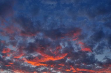 Gökyüzündeki ateş gibi bulutlarla dramatik günbatımı