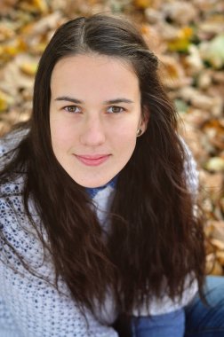 Parktaki sonbahar kızı kameraya bakıyor.