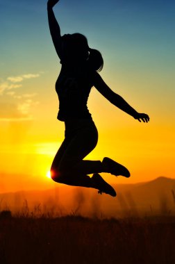 Gün batımında atlayan kız silueti