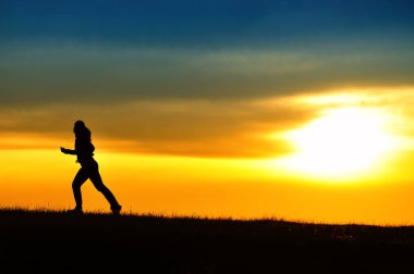 Gün batımında koşan kız silueti