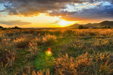 Yoğun gün batımı, gökyüzünü kaplayan devasa bulutlar.