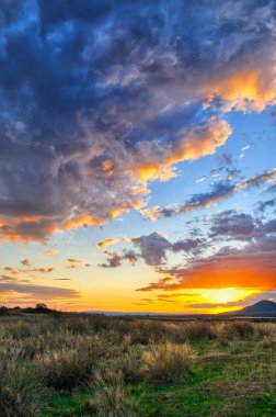 Yoğun gün batımı, gökyüzünü kaplayan devasa bulutlar.
