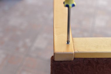 Atölyenin bahçesinde vida, tornavida, matkap, cetvel gibi aletler kullanılarak yapılan bir dizi sandalye tamiri fotoğrafı..