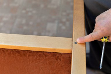 Atölyenin bahçesinde vida, tornavida, matkap, cetvel gibi aletler kullanılarak yapılan bir dizi sandalye tamiri fotoğrafı..