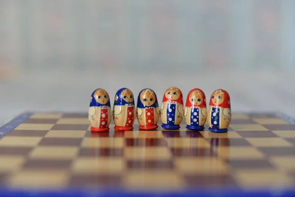 Kendinden tecrit sırasında satranç masası oyunu, parlak matryoshka figürlerinin yakın plan çekimi 