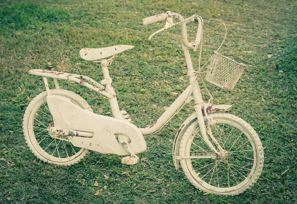 A small old white bicycles with green background — Stock Photo, Image