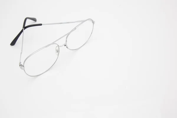 Gümüş çerçeve gözlük köşesinde alanı olan beyaz arka plan üzerinde