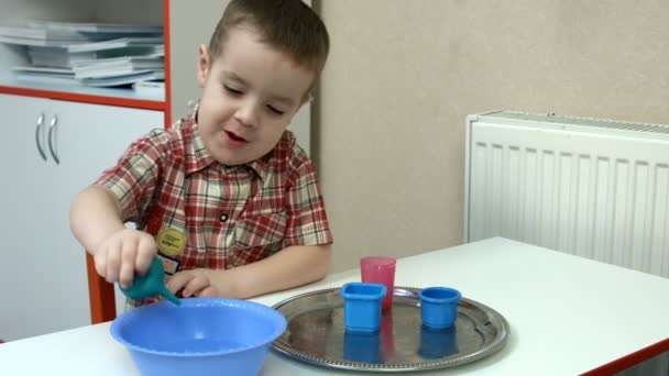 Kleiner Junge studiert Eigenschaften des Wassers — Stockvideo