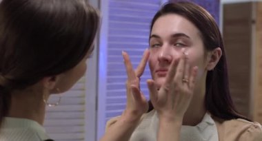 Bu, makyaj yapan genç bir kızın harika bir görüntüsü. Bu 4000x2160 (4K) videosu herhangi bir kadın güzelliğini gösteren video projesinde harika görünecektir. Bu görüntüleri bir sonraki filminiz, Youtube videonuz, belgeseliniz ve daha fazlası ile birleştirin.