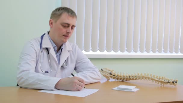 The doctor writes a diagnosis in the medical record — Stock Video