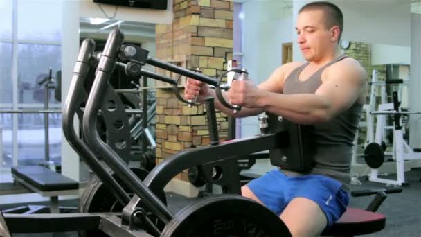 Un hombre entrena en un gimnasio — Vídeos de Stock