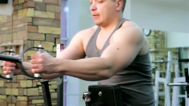 Un hombre entrena en un gimnasio — Vídeos de Stock