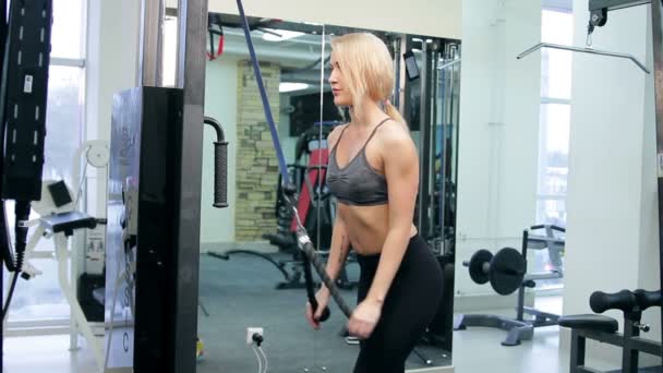 Mujer joven entrenando en un gimnasio — Vídeos de Stock