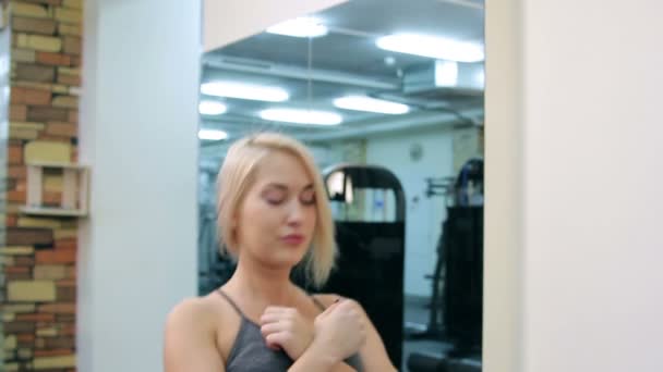 Молода жінка тренується в спортзалі — стокове відео