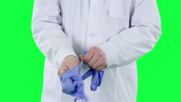 Il dottore si mette i guanti da primo piano. Sfondo chiave cromatico — Video Stock