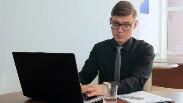 Young man working on laptop in a office — Stock Video