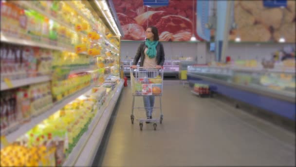 Mujer joven en el supermercado — Vídeo de stock