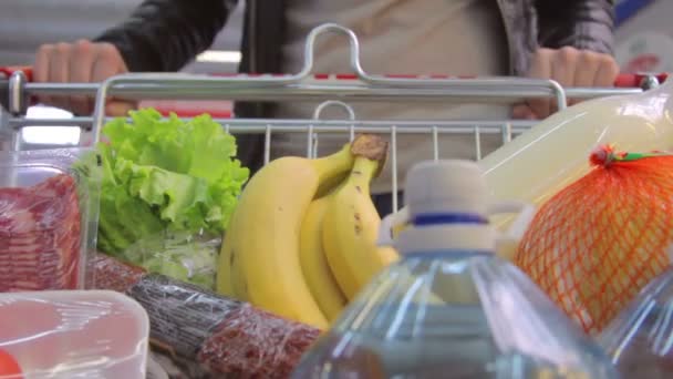 Тележка с покупками разъезжает по супермаркету — стоковое видео