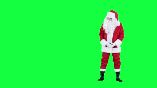 Jultomten ser på något chroma key (grön skärm) — Stockvideo
