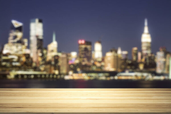 Blank tabletop made of wooden planks with beautiful blurry cityscape at twilight on background, mockup