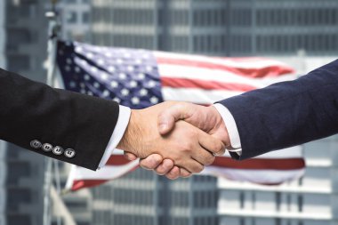 İki işadamı ABD bayrağının arka planında el sıkışıyor, anlaşma konsepti, kapanış