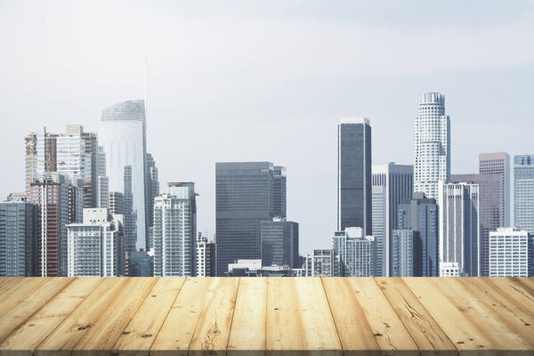 Wooden table top with beautiful Los Angeles skyline on background, mockup