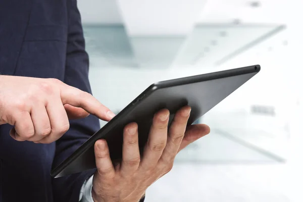Geschäftsmann hält digitales Tablet in der Hand und klickt auf den Bildschirm im modernen Büro, aus nächster Nähe. Suchkonzept — Stockfoto