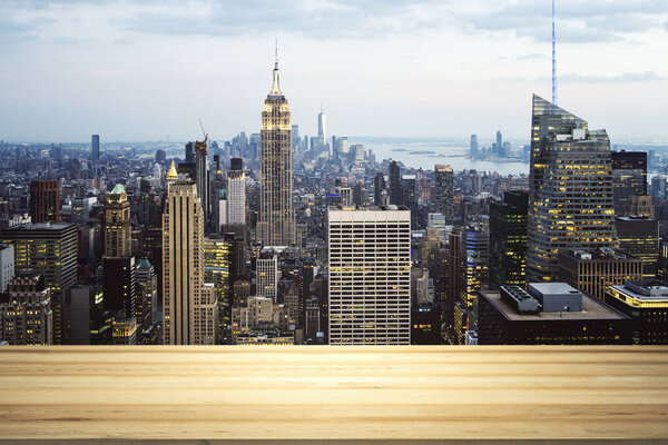 Empty wooden tabletop with beautiful New York skyscrapers at night on background, mock up