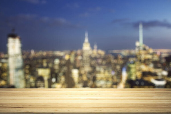 Blank wooden table top with beautiful blurry skyline at night on background, mockup